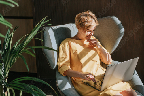 A young woman in the process of working at the computer at home.