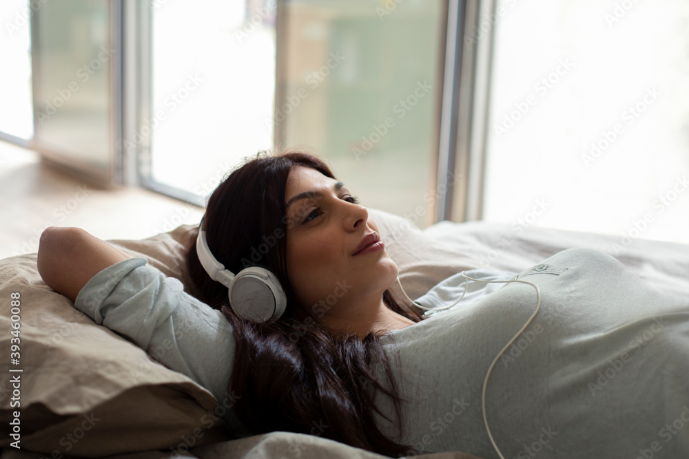 Woman enjoying music on bed Woman enjoying music on bed