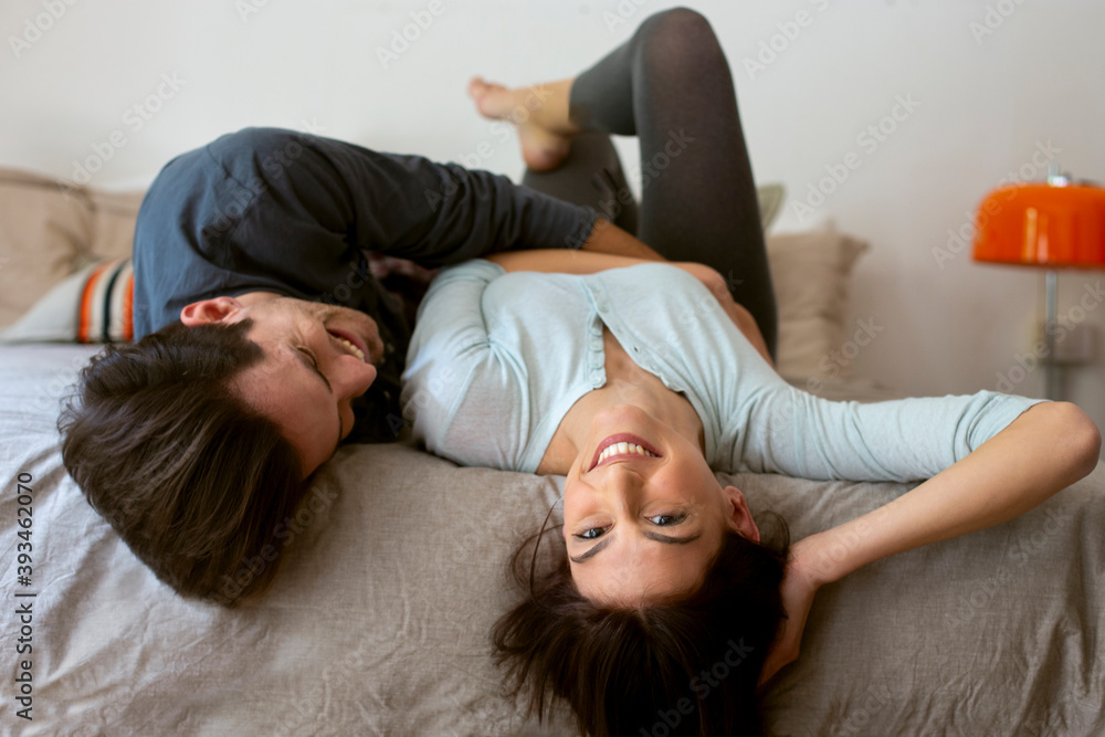 Cheerful couple cuddling on bed Cheerful couple cuddling on bed