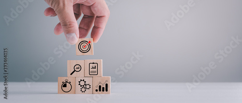 business strategy, Action plan, Goal and target, hand stack woods block step on table with icon about business strategy and Action plan. business development concept. copy space. photo