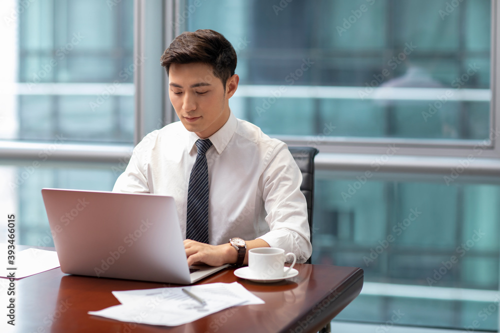 Confident businessman using laptop in office Confident businessman using laptop in office
