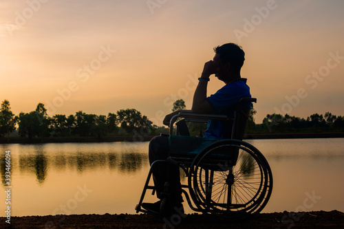 Cuadro en lienzo Silhouette young disabled man seeing river background