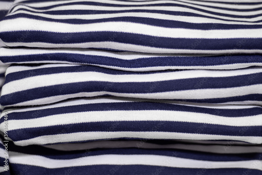 Stack of folded and ironed striped T-shirts close up Stack of folded and ironed striped T-shirts close up