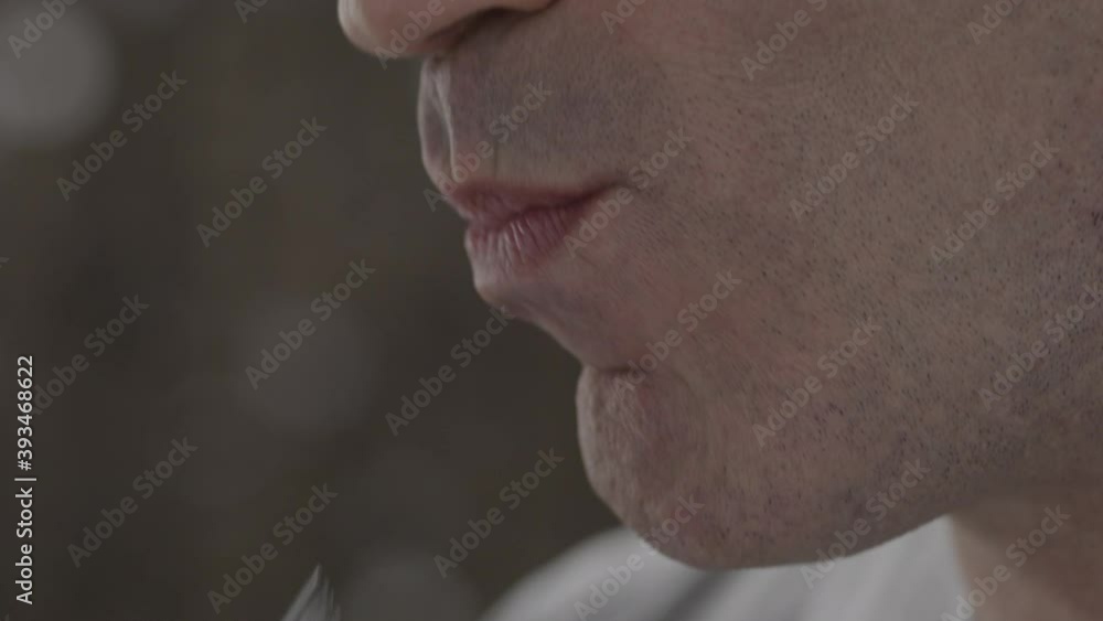 Close-up of unidentified happy man sniffing smiles and eating meat from fork on background of blurry sparkles. Concept of an exquisite restaurant menu. Slow motion Close-up of unidentified happy man sniffing smiles and eating meat from fork on background of blurry sparkles. Concept of an exquisite restaurant menu. Slow motion