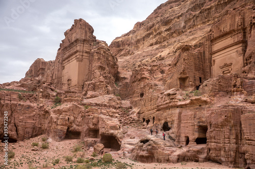 A group of tourists climbs the stones of the ruined city of Petra