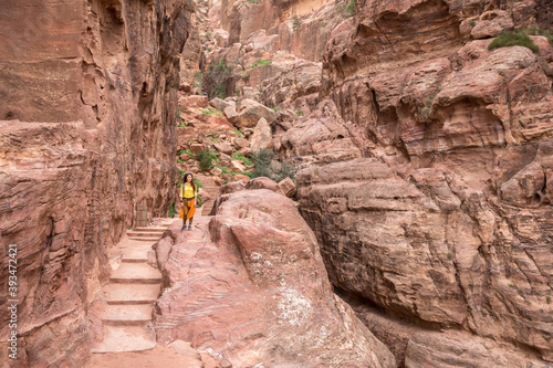 Wallpaper Mural A girl tourist in a yellow shirt and a backpack stands in the mountains on stone steps carved from stone Torontodigital.ca