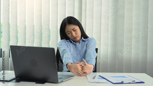 Asian woman who sits for a long time and gets pain and stretches her muscles. photo