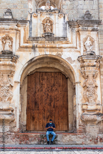 man with face mask in front of a church in antigua guatemala © Joel Aguilar