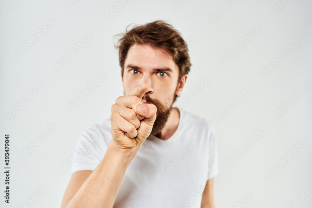 Bearded man gesturing with hands cropped view white t-shirt studio emotion light background Bearded man gesturing with hands cropped view white t-shirt studio emotion light background