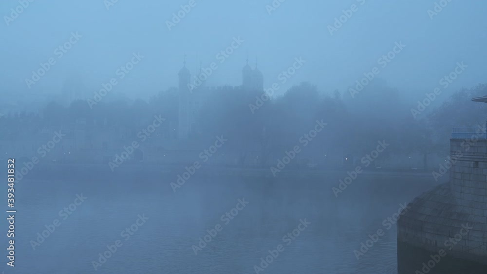 Coronavirus Covid-19 lockdown day one in thick foggy weather conditions at Tower of London on a misty cool blue atmospheric morning with fog and mist on the River Thames in London, England, UK Coronavirus Covid-19 lockdown day one in thick foggy weather conditions at Tower of London on a misty cool blue atmospheric morning with fog and mist on the River Thames in London, England, UK