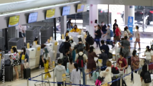 Blurred and unrecognizable Asian people waiting to check in at the airport. everyone wearing disposal face mask for protect coronavirus. airport open after covid-19 epidemic