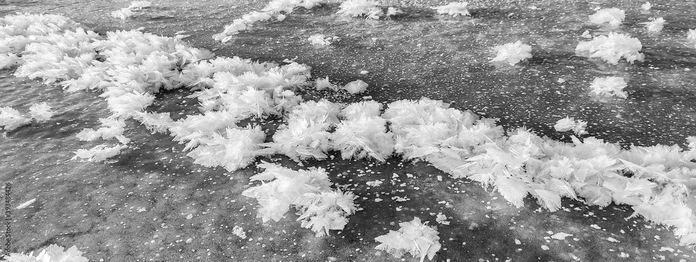 Fototapeta premium black-white patterns of snowflakes and ice crystals of air on the surface of the ice. Abstract background
