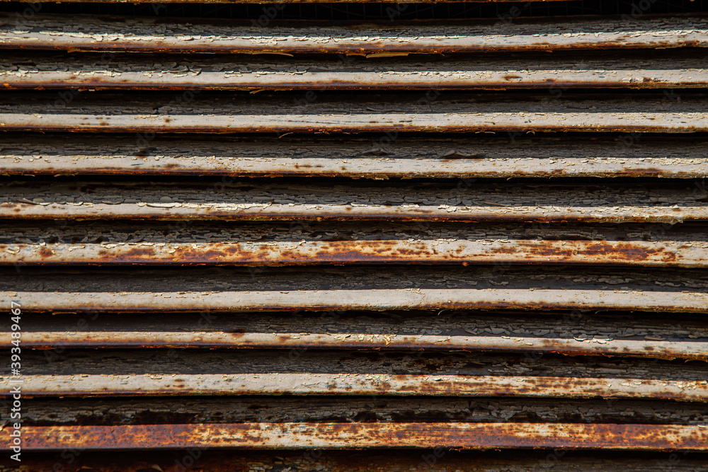 Rusty metal grilles, painted with paint and peeled off from old age, ventilation holes for air ingress in industrial facilities, an electric shield, an opening door Rusty metal grilles, painted with paint and peeled off from old age, ventilation holes for air ingress in industrial facilities, an electric shield, an opening door