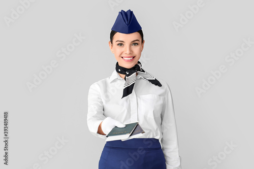 Beautiful stewardess on grey background photo