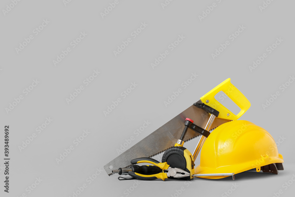 Hardhat and construction tools on grey background Hardhat and construction tools on grey background