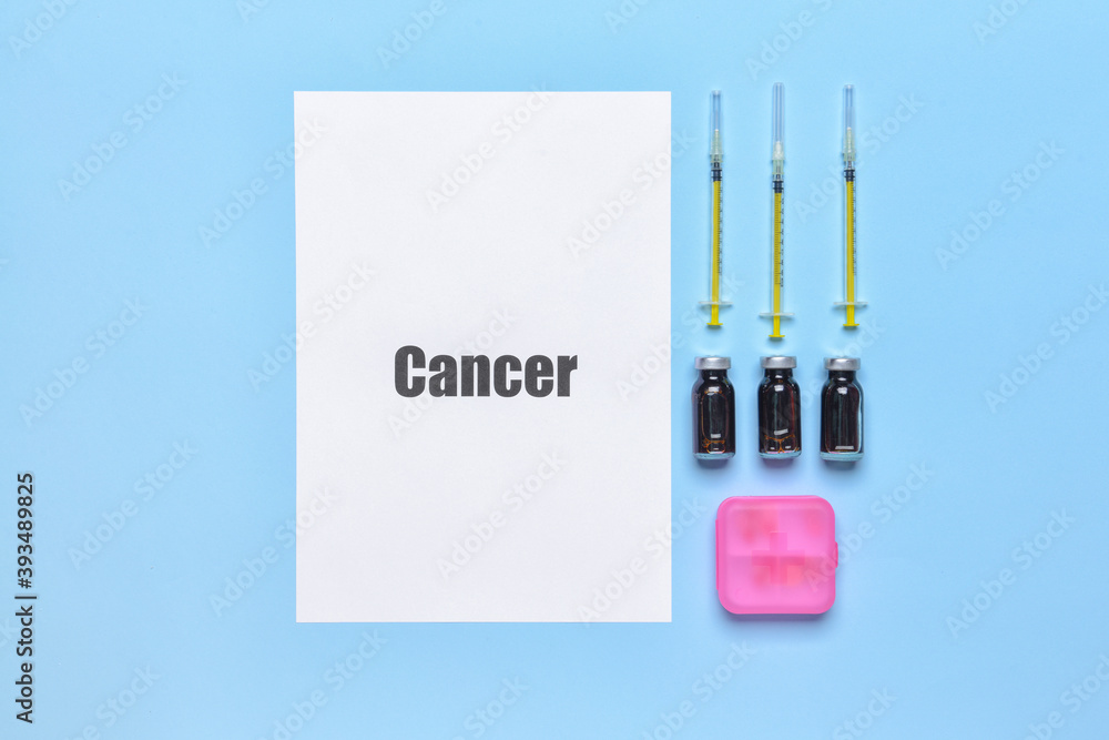 Paper sheet with word CANCER and medications on color background Paper sheet with word CANCER and medications on color background