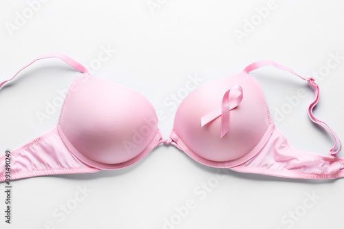 Pink ribbon and bra on light background. Breast cancer awareness concept