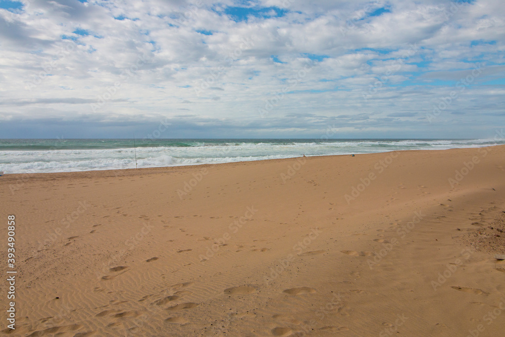 Footprints in Sand on Beach Leading Down to Ocean Waves Footprints in Sand on Beach Leading Down to Ocean Waves