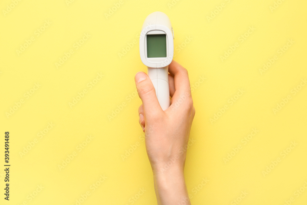 Hand with infrared thermometer on color background Hand with infrared thermometer on color background