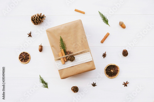 Handmade wrapped gift box with natural decorations such as pine cones, fir branch, cinnamon sticks, dry orange slice.Zero waste Christmas concept. Plastic free holidays. Sustainable lifestyle.