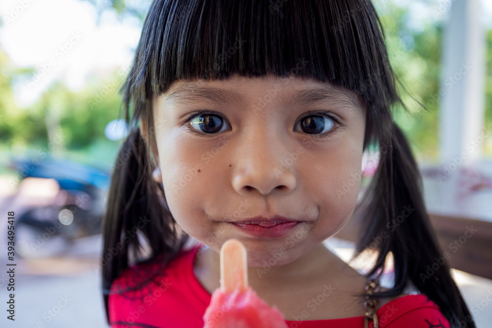 The cute little Asian girl is happily eating ice cream. The cute little Asian girl is happily eating ice cream.