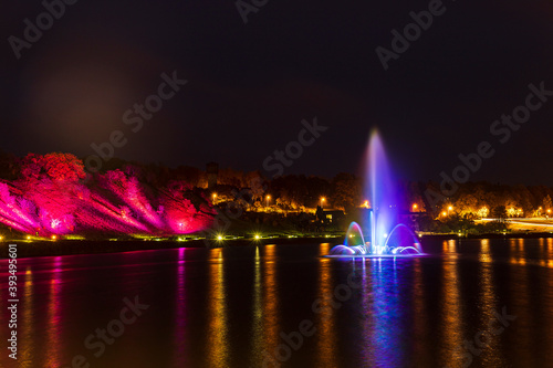 Illuminated, colored fountain in the middle of the lake