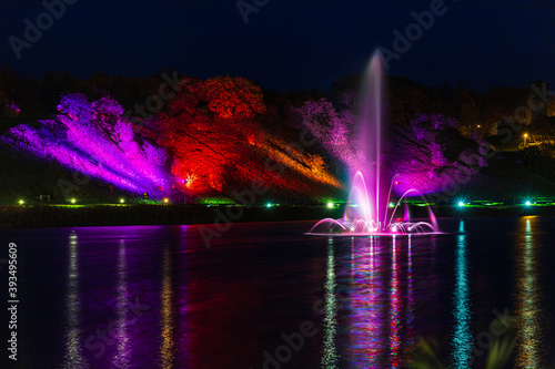 Illuminated, colored fountain in the middle of the lake