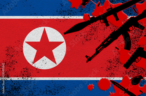 North Korea flag and various weapons in red blood. Concept for terror attack or military operations with lethal outcome photo