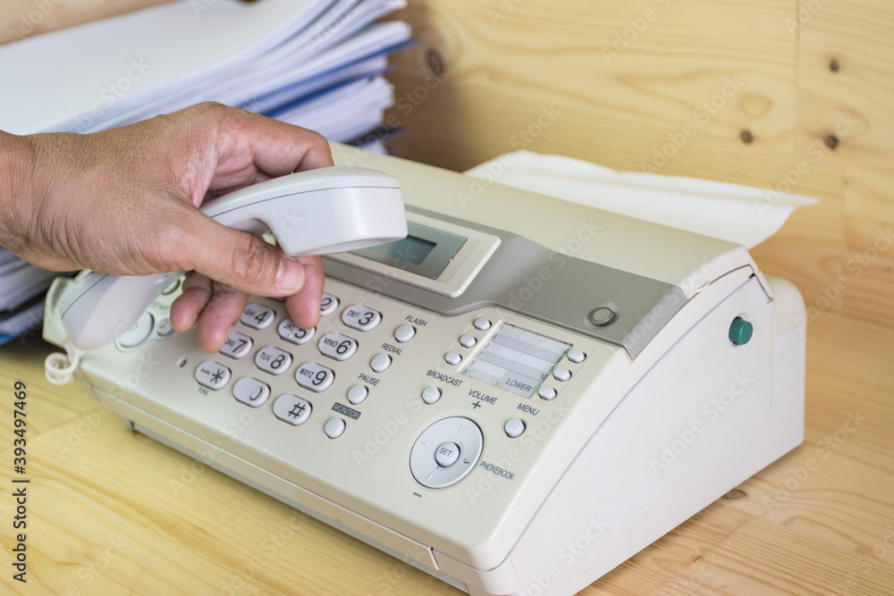 hand man are using a fax machine in the office, equipment for data transmission. hand man are using a fax machine in the office, equipment for data transmission.