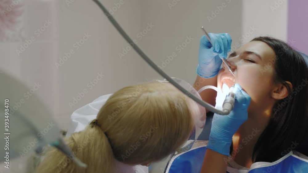 Dentist doing a dental treatment on a female patient. Dentist doing a dental treatment on a female patient.