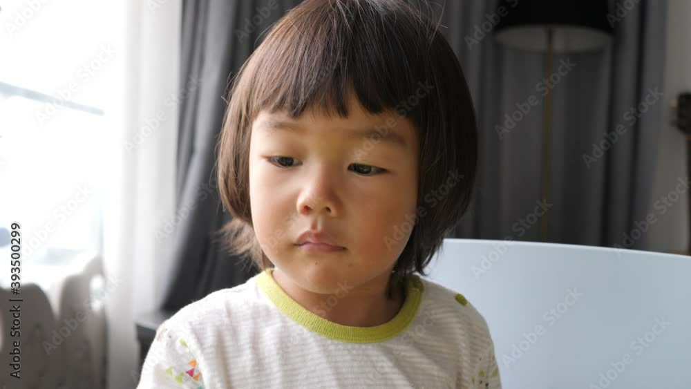 Asian boy watching a tablet and scratching his nose. Asian boy watching a tablet and scratching his nose.