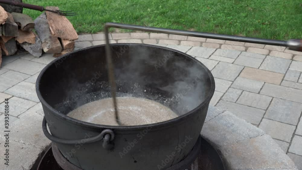 Mixing ground meat or puttons in an iron kettle over a wood fire. Mixing ground meat or puttons in an iron kettle over a wood fire.