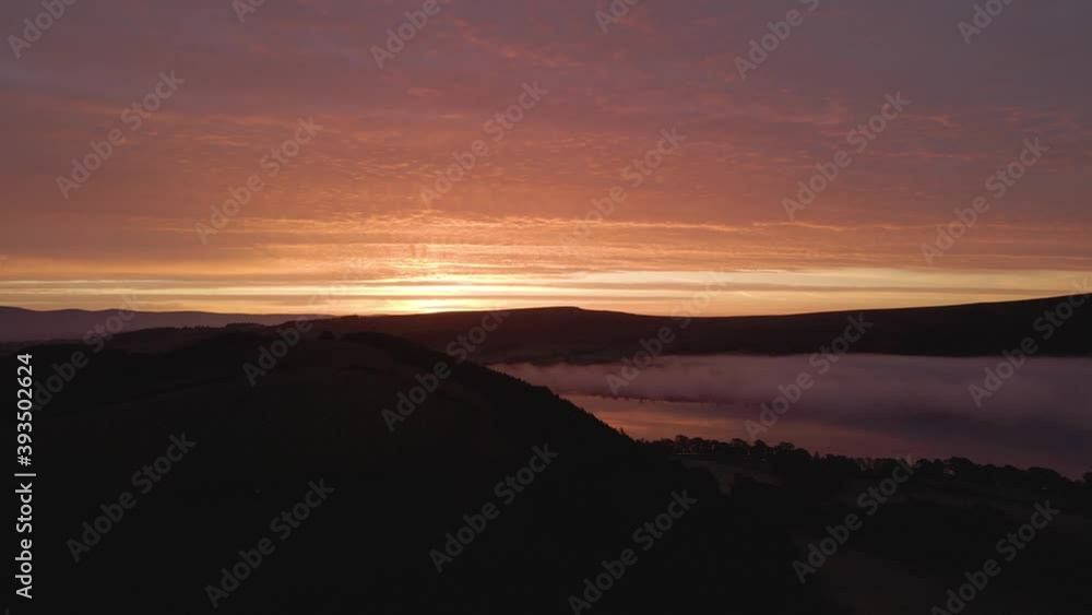 Orange sunrise over cloud inversion in the Lake District, aerial pan up Orange sunrise over cloud inversion in the Lake District, aerial pan up