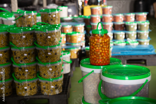 Pickled olives in plastic containers at store warehouse. High quality photo