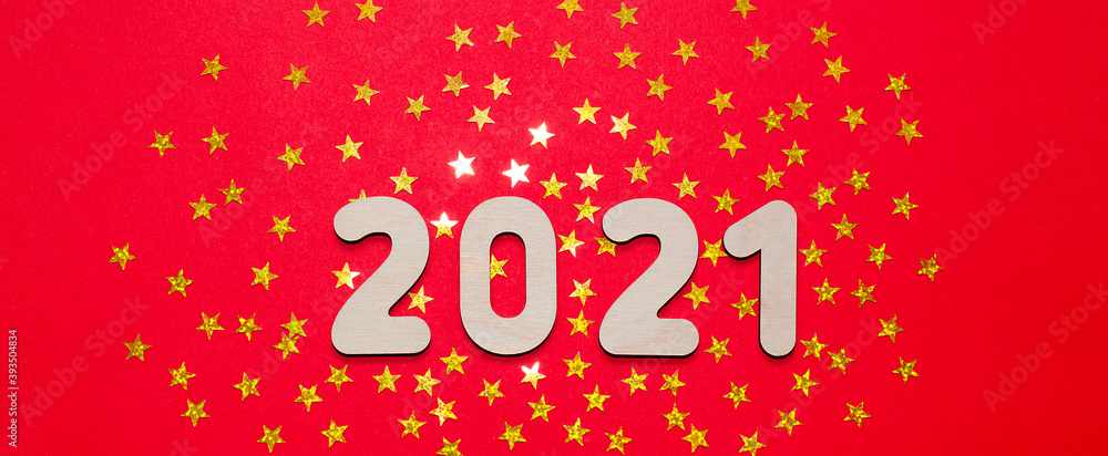 Merry Christmas and New year 2021 - Golden numbers on a red - orange background with sparkling stars. Copy space and flat lay. Space for text.
