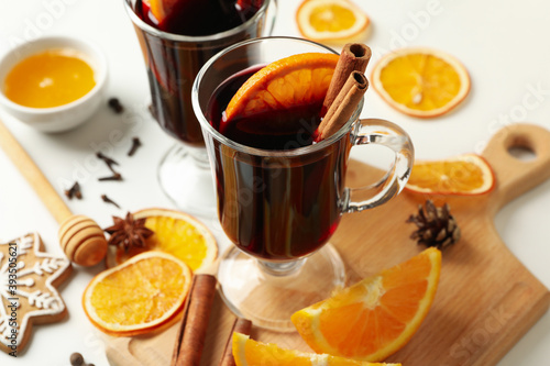 Cups of mulled wine and ingredients on white background