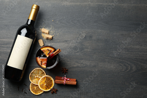 Cuadro en lienzo Bottle of wine, cup of mulled wine and ingredients on wooden background