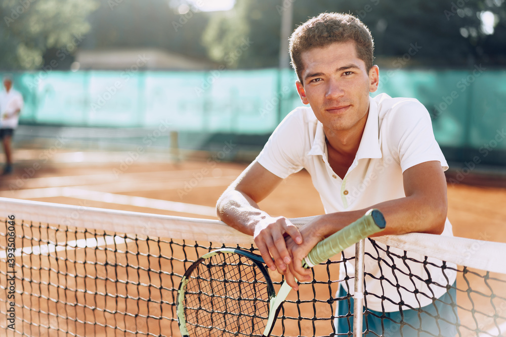 Fototapeta premium Young mixed race man tennis player with racket standing on tennis court
