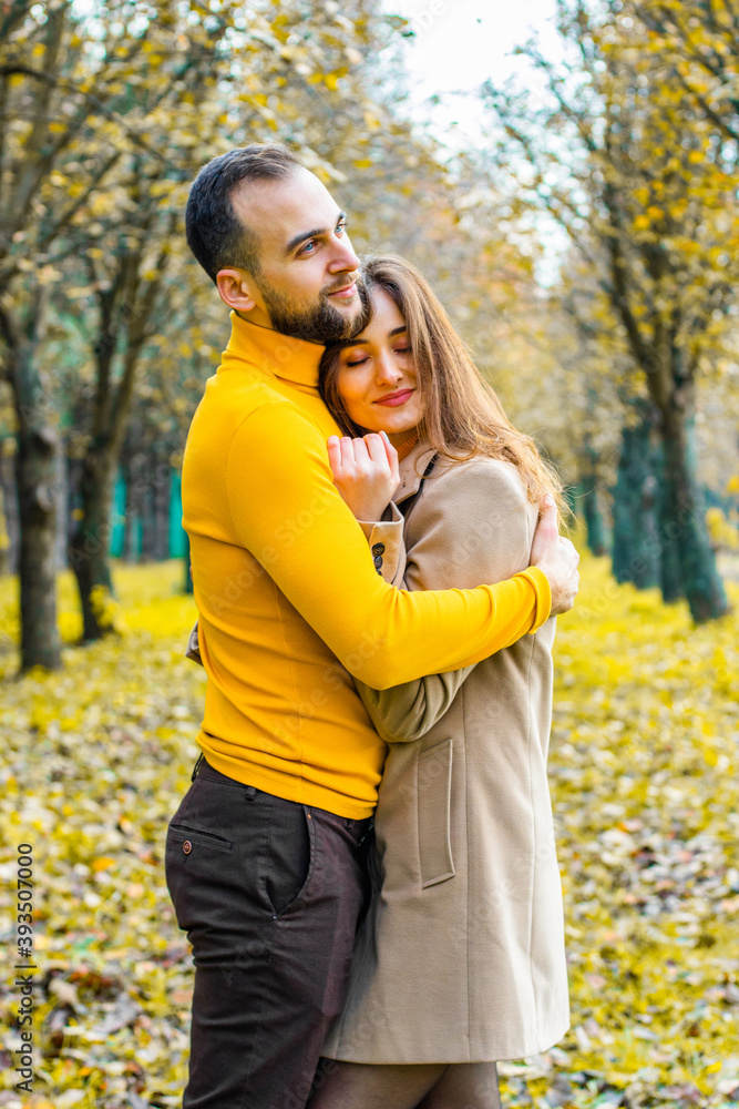 Couple of lovers dressed in yellow turtlenecks in the park hugging Couple of lovers dressed in yellow turtlenecks in the park hugging