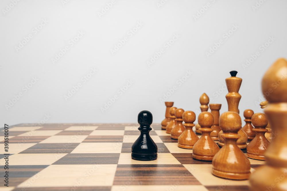 Fototapeta premium Chessboard with wooden figures against grey background