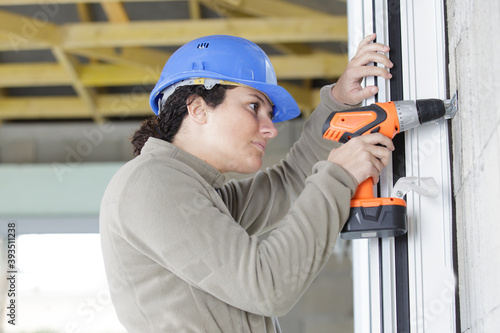 Foto female construction worker holding screwdriver handtool and cordless screwdriver