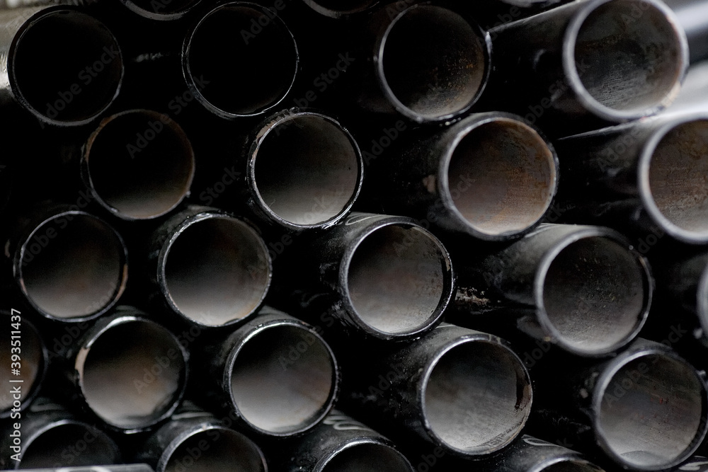 Black metal pipes and adapters of different diameters for gasification or water supply. Industrial background Black metal pipes and adapters of different diameters for gasification or water supply. Industrial background