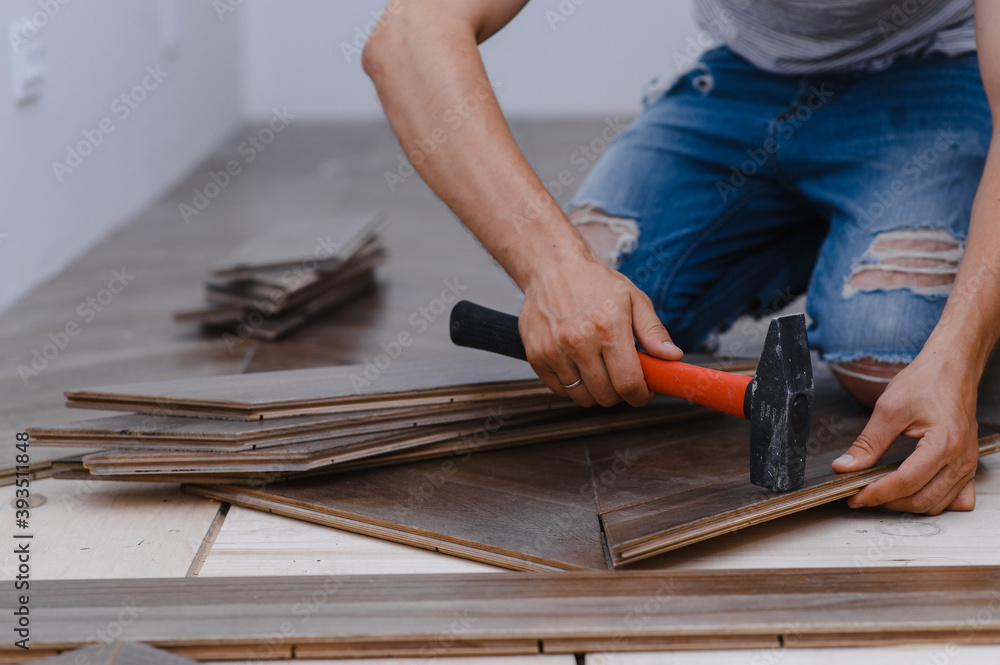 Man laying parquet flooring - closeup on male hands. worker joining parquet floor Man laying parquet flooring - closeup on male hands. worker joining parquet floor