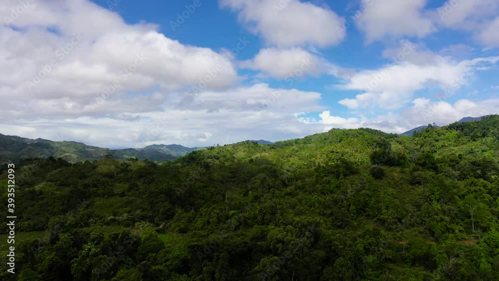 Aerial view of mountains covered rainforest and with rain clouds. Philippines, Luzon. Mountain landscape on tropical island with mountain peaks covered with forest. Slopes of mountains with evergreen Aerial view of mountains covered rainforest and with rain clouds. Philippines, Luzon. Mountain landscape on tropical island with mountain peaks covered with forest. Slopes of mountains with evergreen