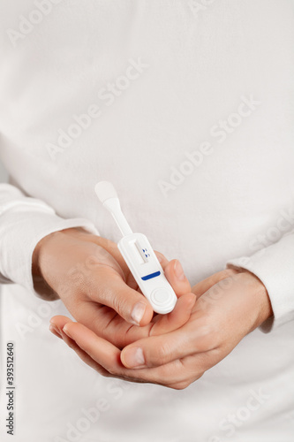 Man holding oral HIV test on white background.