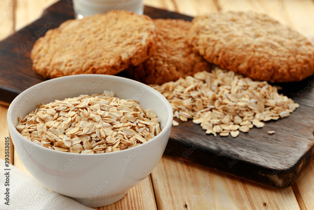 Oat cookies and oat flakes on wooden surface Oat cookies and oat flakes on wooden surface