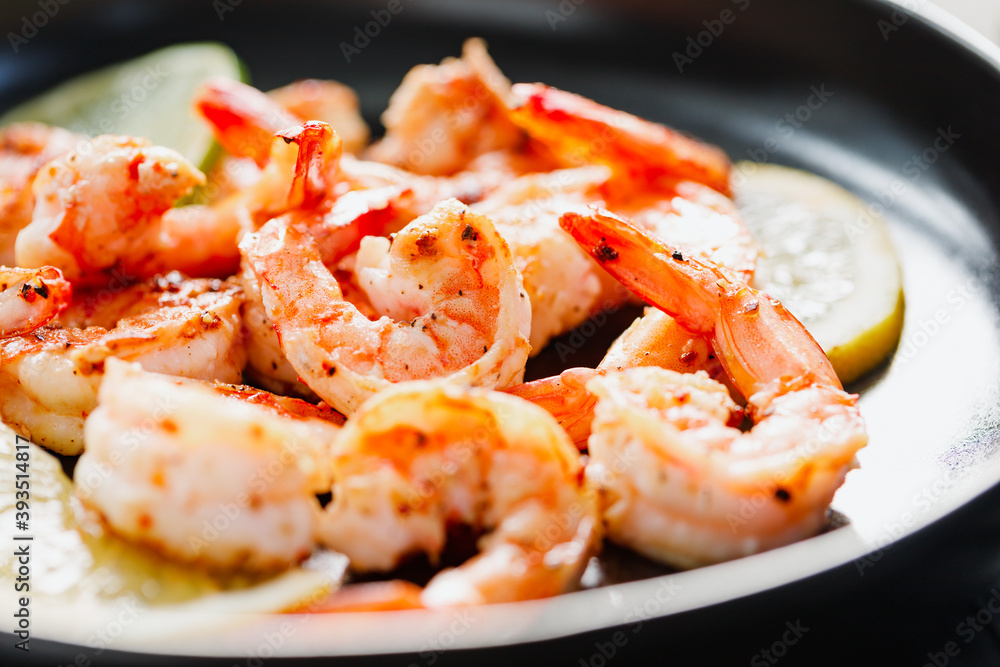 Fried tiger shrimp with lime, lemon and spices on a ceramic dish. Healthy dinner or lunch concept. Fried tiger shrimp with lime, lemon and spices on a ceramic dish. Healthy dinner or lunch concept.