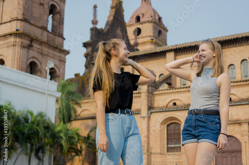 Young female friends standing on the background of Santa Cruz de la Sierra cathedral