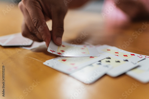 Happy latin american family playing cards at home. Young people having fun and laughing playing cards in the living room in home