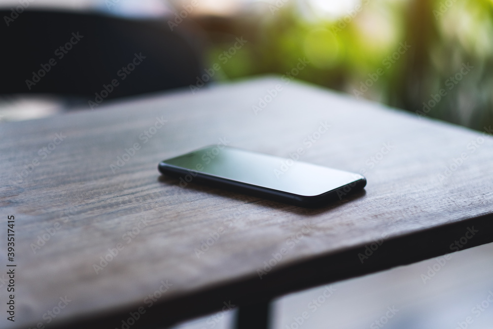 A mobile phone on wooden table A mobile phone on wooden table